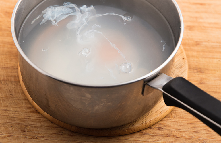 Cracking eggs directly into the poaching water
