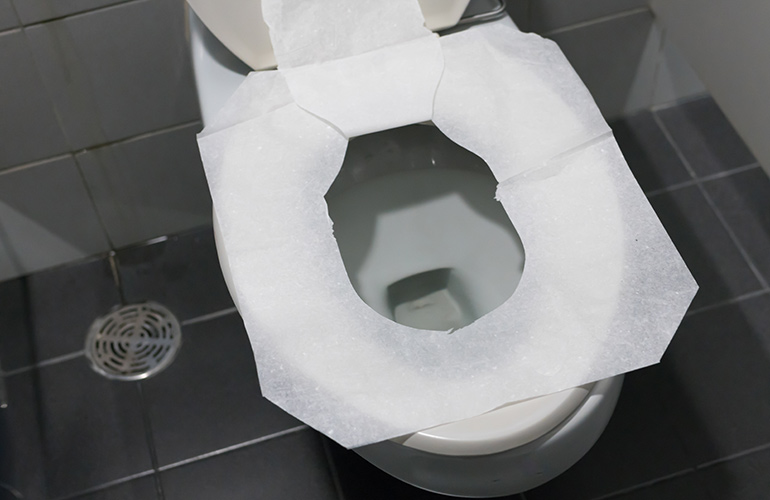 Using a paper toilet seat cover