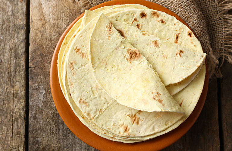 Sprinkle a wholemeal tortilla with 60 grams grated, low-fat cheddar cheese and grill