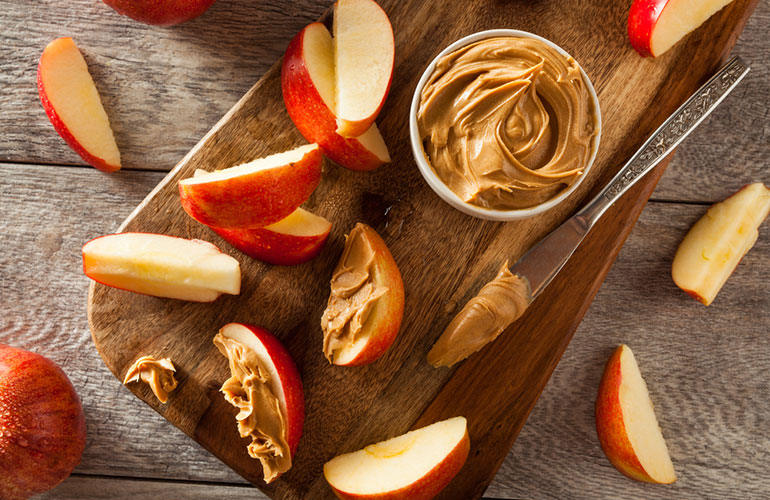 Spread apple slices with peanut butter