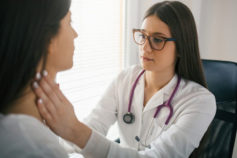doctor checking thyroid