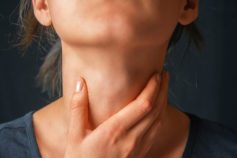 woman feeling for lumps in her neck
