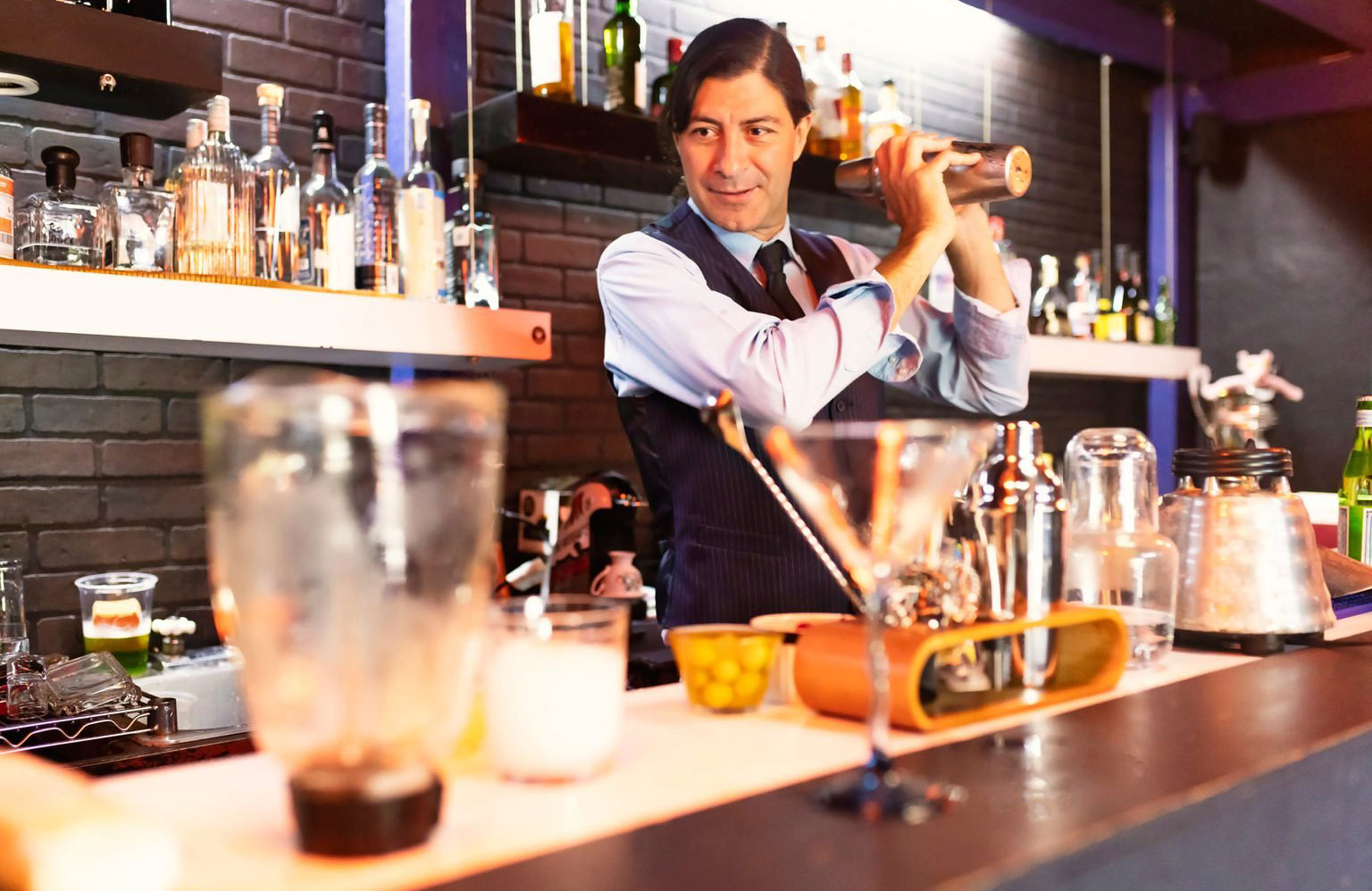 Reaching over or behind the bar to grab something quickly