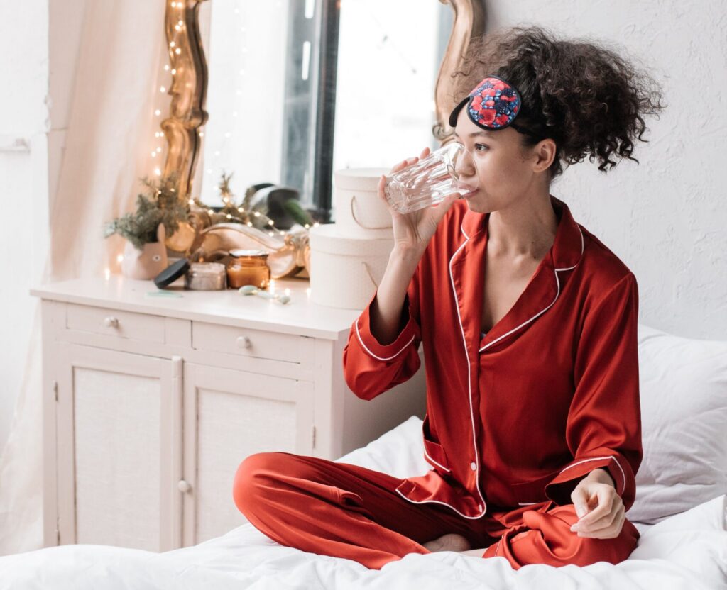 lady in bed drinking water from a glass