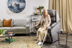 a senior with walking stick getting up from a lift chair