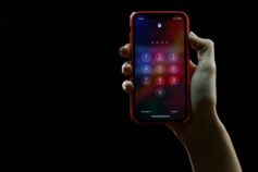 a hand holding a phone showing the passcode screen