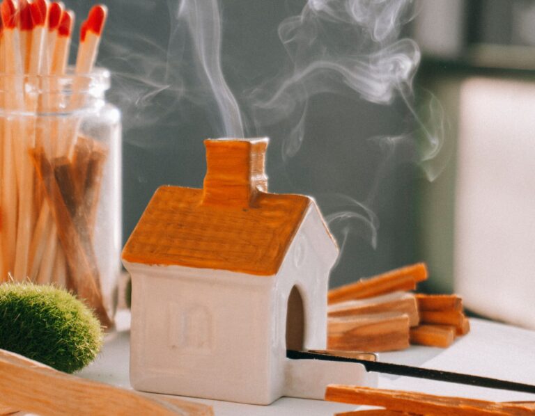 A miniature house with aromatic smoke rising from the chimney