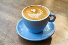 A blue cup of coffee on a marble table.