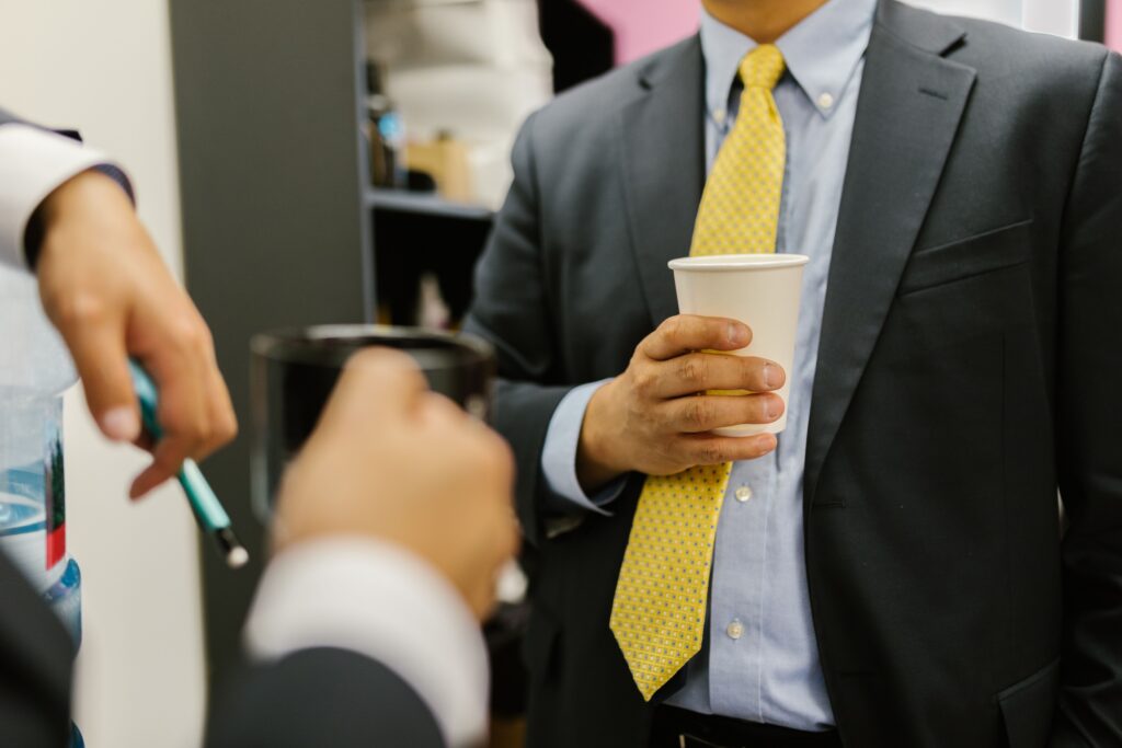 Three colleagues taking a coffee break, drinking coffee and chatting together.