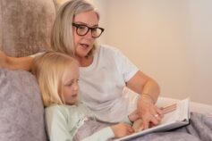 Grandmother reading a book with her young granddaughter.
